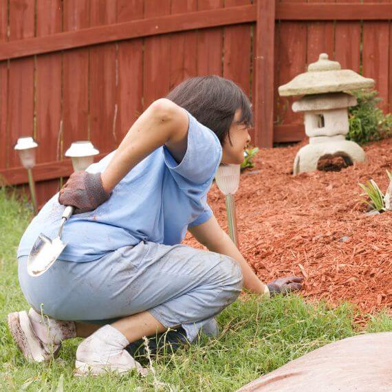 Woman Suffering The Challenge Of Gardening And Back Pain